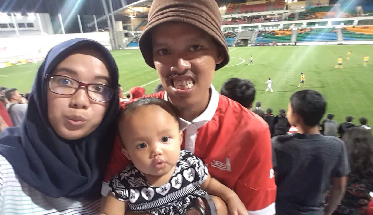 Seorang The Jakmania bernama Mustopha mengajak istri dan sang putri yang masih berusia delapan bulan untuk away days saat Persija Jakarta tandang ke Singapura pada laga AFC Cup. (Bola.com/Istimewa)