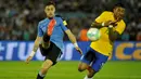 Gelandang Brazil, Paulinho, berusaha menghalau tendangan bek Uruguay, Sebastian Coates. Paulinho mencetak tiga gol dalam pertandingan tersebut. (AFP/ Dante Fernandes)