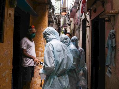 Petugas kesehatan India yang mengenakan alat pelindung diri melakukan pemeriksaan COVID-19 di kawasaan permukiman kumuh di tengah penyebaran wabah tersebut di Mumbai, India (17/6/2020). (Xinhua/Stringer)