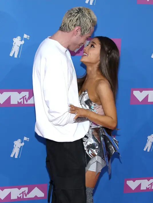Ariana Grande terlihat cantik dengan silver mini dress dan sepatu boots yang berkilau. Sementara Pete Davidson hadir dengan pakaian yang lebih casual. (Paul Zimmerman/Cosmopolitan)