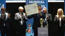 Presiden Paraguay, Alejandro Dominguez (tengah) memegang sertifikat yang mengesahkan Argentina, Paraguay, dan Uruguay sebagai negara tuan rumah Piala Dunia FIFA 2030 selama Kongres virtual FIFA di Luque, Paraguay pada 11 Desember 2024. (AFP/Daniel Duarte)