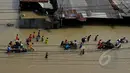 Pengendara motor menggunakan jasa gerobak untuk melewati banjir yang menggenangi Jalan KH Hasyim Ashari, Ciledug, Kota Tangerang, Selasa (10/2/2015). (Liputan6.com/Andrian M Tunay)