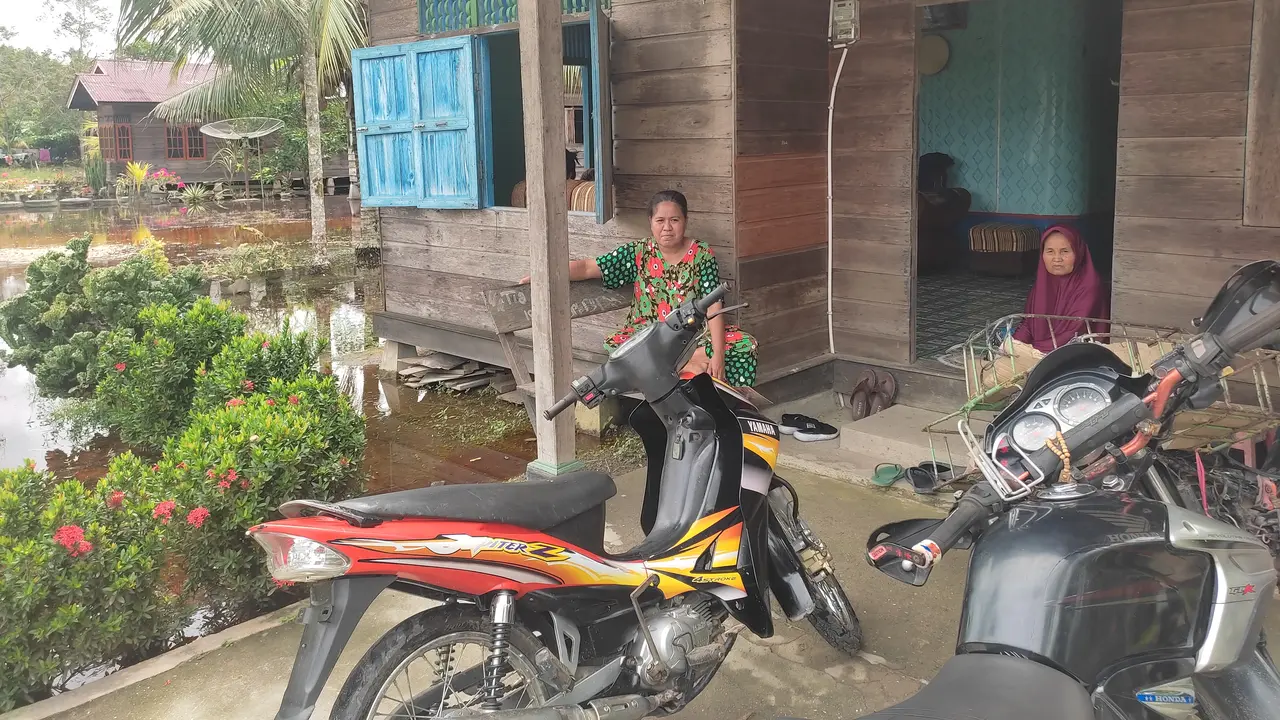 Zumilah (baju hijau) dan keluarga akhirnya bisa mendapatkan akses air bersih di Desa Lubuk Muda berkat inovasi Filtrasi Air Gambut dari Pertamina (Liputan6.com/Jonathan Pandapotan Purba)