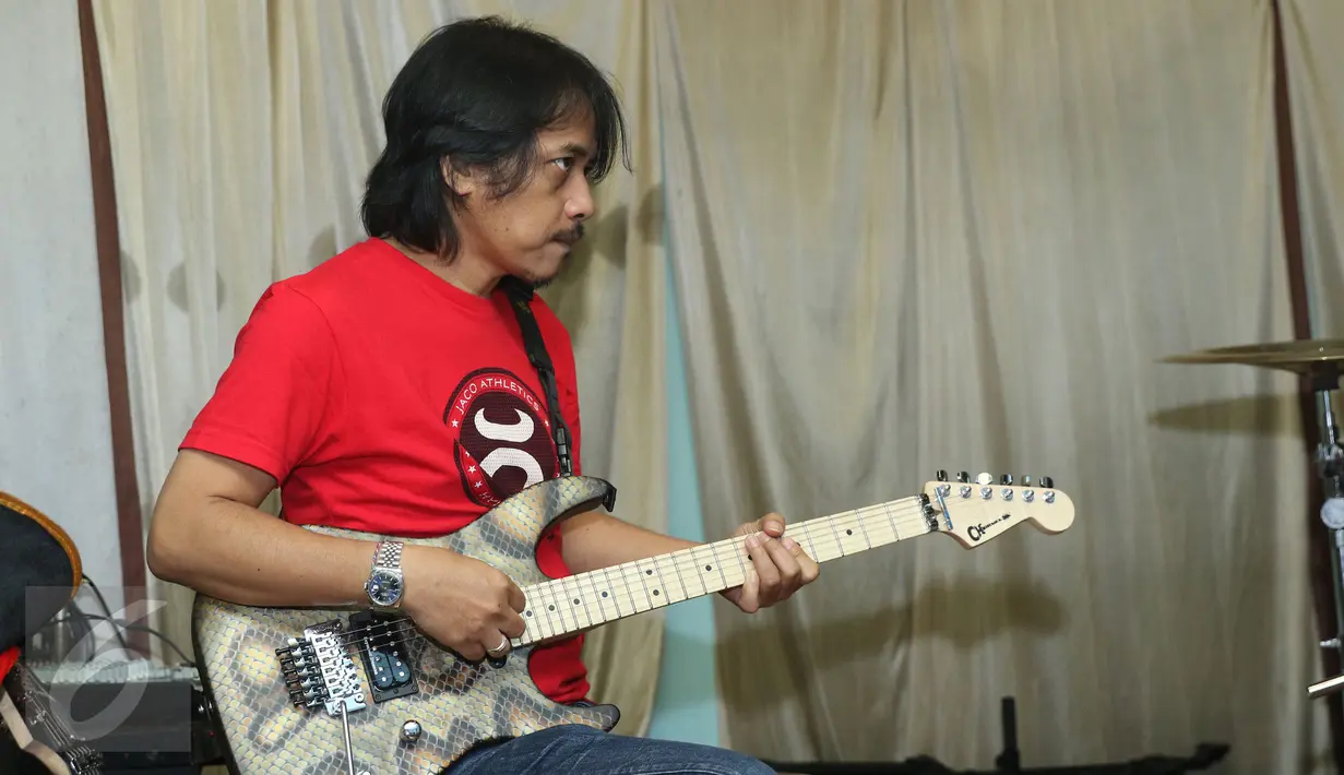 Gitaris GIGI, Dewa Budjana disela proses rekaman soundtrack sinetron Ramadan "Para Pencari Tuhan Jilid 10" di Base Camp GIGI, Jakarta, Senin (9/5) malam. GIGI dipercaya untuk menggarap single bertajuk Gerbang Rahmat. (Liputan6.com/Herman Zakharia)