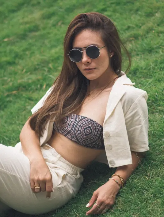 <p>Berpose di atas rumput, Wulan Guritno tampil monokrom dengan set linen berwarna nude. Sebagai aksen, ia mengenakan strapless bra tribal yang membuatnya terlihat trendy. (instagram/wulanguritno)</p>