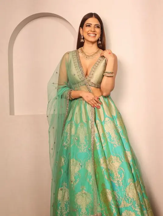 Malavika Mohanan tampil dengan lehenga warna hijau dengan atasan sleeveless crop dipadukan selendang transparan dan rok dengan gambar gold. [@malavikamohanan_]