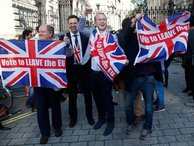 Pendukung Brexit mengibarkan bendera Inggris setelah melihat hasil penghitungan sementara referendum Inggris yang menunjukkan mayoritas rakyat Inggris memilih “Brexit” alias keluar dari Uni Eropa, di London, Kamis (23/6). (REUTERS/Neil Hall)