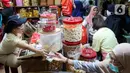 Warga membeli kue kering di salah satu pusat penjualan kue di pasar Jatinegara, Jakarta, Kamis (28/3/2024). (Liputan6.com/Herman Zakharia)