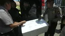 Anggota kepolisian mengangkat kotak berisikan potongan tubuh yang diduga korban jatuhnya pesawat M28 Skytruck milik Polri di Pelabuhan Telaga Punggur, Batam, Kepulauan Riau, Minggu (4/12). Pesawat itu membawa 5 kru dan 8 penumpang. (SEI RATIFA/AFP)