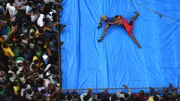 Sejumlah penonton memadati ring, saat pegulat bertarung di Kolkata, India (18/10). Pertandingan gulat ini digelar di tengah jalan yang padat di daerah Kolkata. (AFP Photo/Dibyangshu Sarkar)