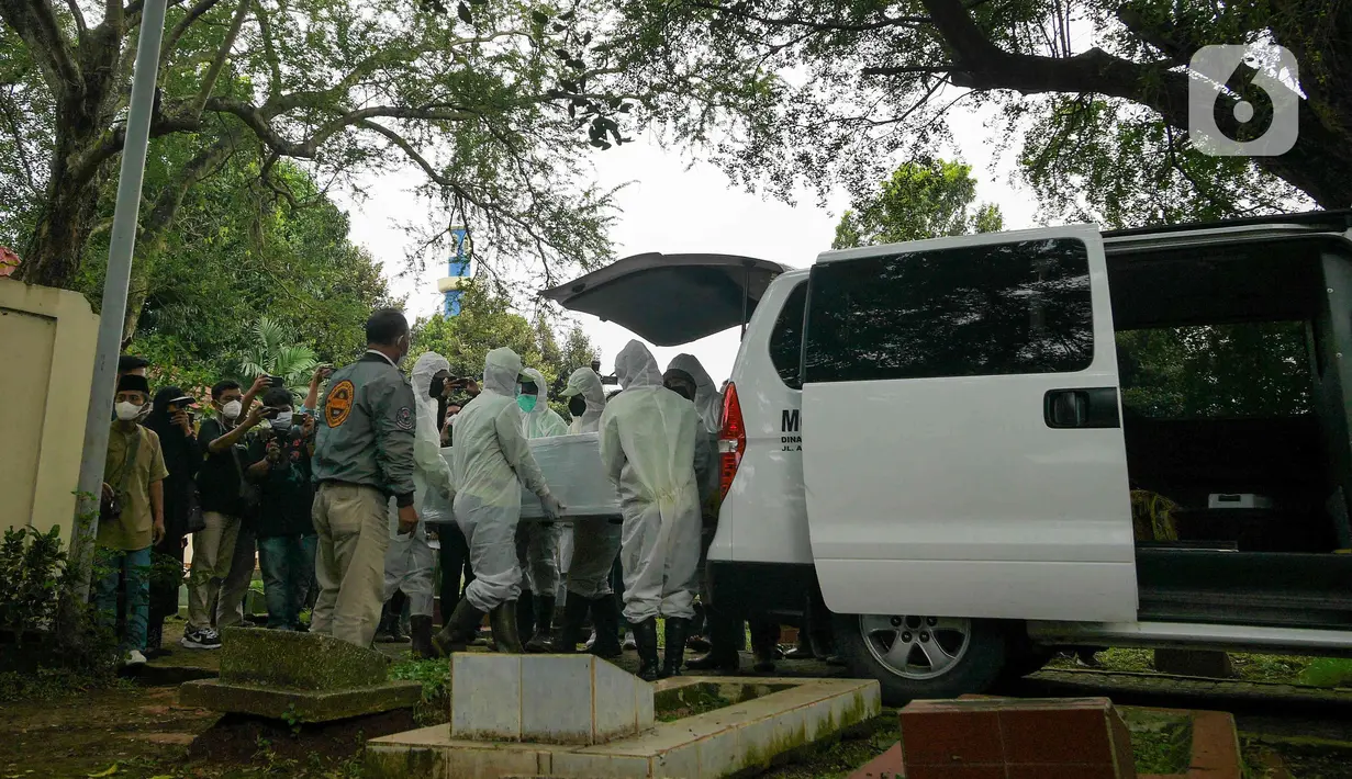 Petugas menurunkan peti jenazah Dedi Yuliardi Ashadi atau Dorce Gamalama saat tiba di TPU Bantar Jati, Bambu Apus, Jakarta, Rabu  (16/2/2022). Ia berpulang setelah terpapar virus COVID-19. Dorce dimakamkan menggunakan protokol COVID-19 di TPU Bantar Jati, Bambu Apus. (Liputan6.com/Herman Zakharia)