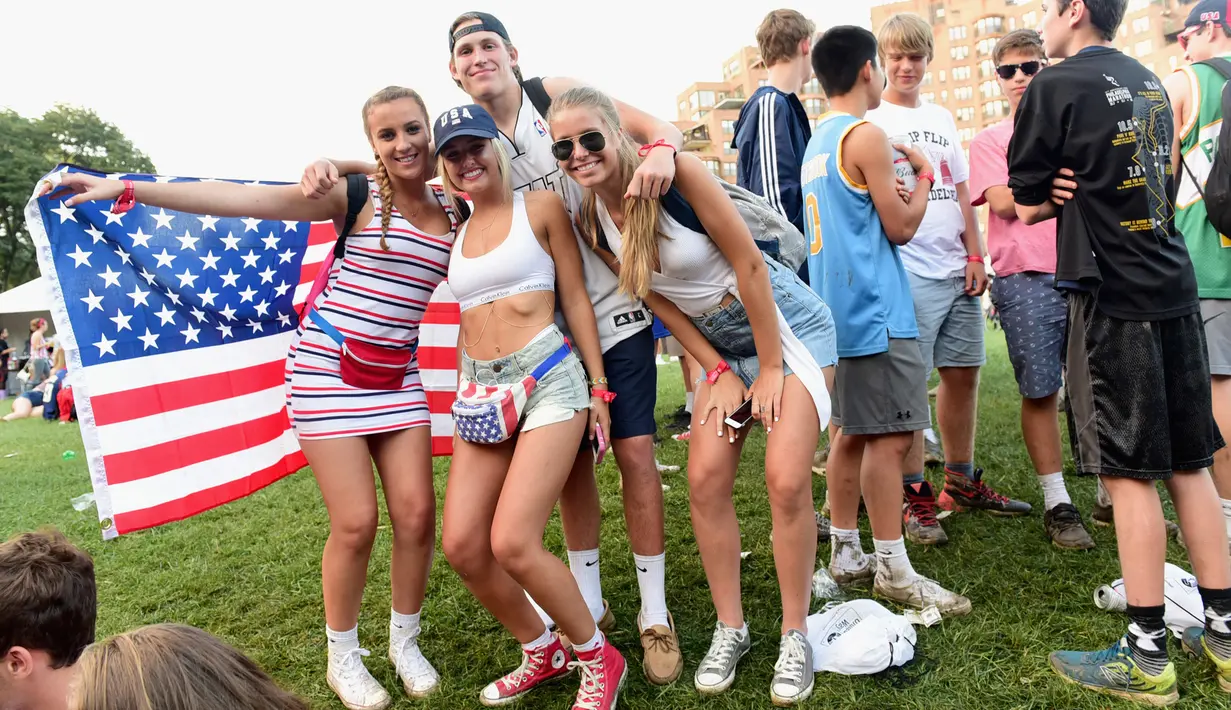Sejumlah gadis berpose dengan bendera Amerika Serikat saat menghadiri hari ke 2 Festival Budweiser Made in America 2017 di Benjamin Franklin Parkway di Philadelphia, Pennsylvania (3/9). (Lisa Lake/Getty Images for Anheuser-Busch/AFP)