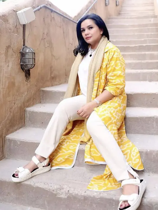 Yanti Airlangga istri dari Koordinator Bidang Perekonomian Indonesia, tampil stylish dengan long outer warna kuning, dipadu dengan inner, celana, hingga sandal putihnya. Ia pun mengenakan syal sebagai pelengkap penampilannya. Dok. @yanti.airlangga