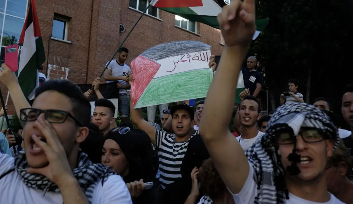 Para demonstran membawa bendera Palestina dan meneriakkan bebaskan Palestina di depan kedutaan besar Israel di Madrid (14/07/2014) (AFP PHOTO/PEDRO ARMESTRE)