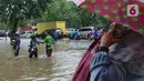 Warga melintasi genangan banjir yang menutupi Jalan Letjen Suprapto, Cempaka Putih, Jakarta Pusat, Kamis (29/2/2024). (merdeka.com/Arie Basuki)