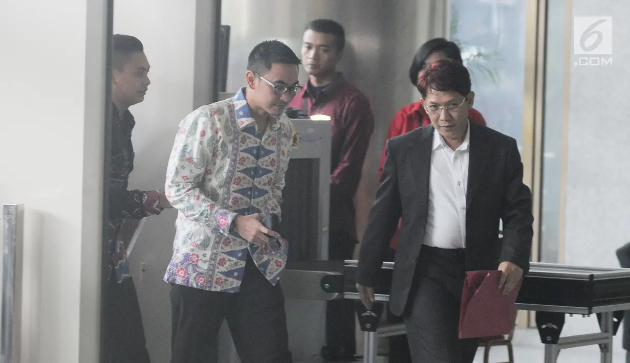 Gubernur Jambi Zumi Zola memasuki Gedung KPK untuk menjalani pemeriksaan, Jakarta, Kamis (15/2). Didampingi dua orang pria, Zumi Zola tampak santai dan sesekali tersenyum pada awak media. (Liputan6.com/Herman Zakharia)