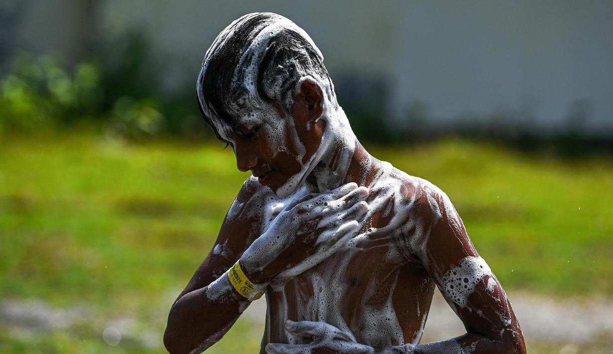 Seorang pengungsi Rohingya mandi di tempat penampungan sementara di Ladong, provinsi Aceh, Kamis 24 Februari 2023. Sedikitnya 69 pengungsi Rohingya mendarat di pantai barat Indonesia pada 16 Februari lalu dengan sebuah perahu kayu. (CHAIDEER MAHYUDDIN/AFP)