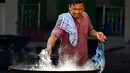 Bagi warga Aceh, kuah Beulangong merupakan hidangan primadona untuk berbuka puasa, sering kali dimasak di masjid atau meunasah untuk dinikmati bersama. Tampak dalam foto, seorang pria memasak hidangan kari tradisional yang disebut 'kuah beulangong' untuk dibagikan saat berbuka puasa, sekaligus memperingati turunnya Al-Quran selama bulan suci Ramadan, di Banda Aceh pada Sabtu 7 Maret 2026. (CHAIDEER MAHYUDDIN/AFP)