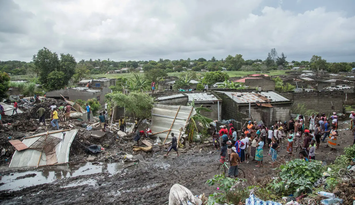 Sejumlah warga melihat proses pencarian para korban yang tertimbun gunungan sampah longsor di ibu kota Mozambik, Maputo,  Senin (19/2). Hujan lebat diperkirakan merupakan pemicu insiden di distrik miskin Maputo itu. (MAURO VOMBE / AFP)