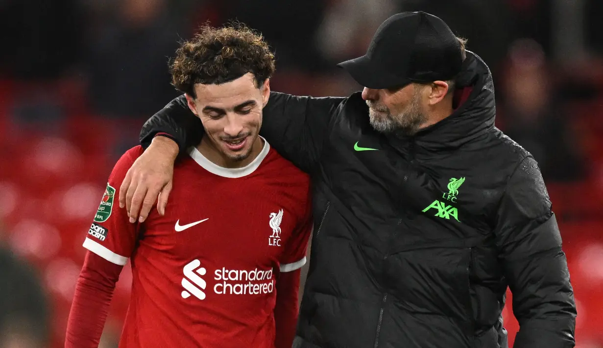 Pelatih Liverpool, Jurgen Klopp berbincang dengan pemain Liverpool, Curtis Jones pada laga perempat final Carabao Cup 2023/2024 di Anfield, Liverpool, Inggris, Kamis (21/12/2023) dini hari WIB. (AFP/Oli Scarff)