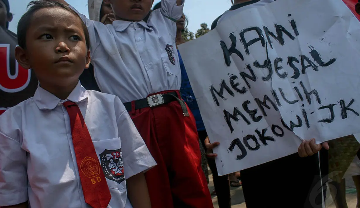 Seorang anak tampak membawa poster bertuliskan "Kami Menyesal Memilih Jokowi-JK" di depan Balai Kota, Jakarta, (22/9/14). (Liputan6.com/Faizal Fanani)