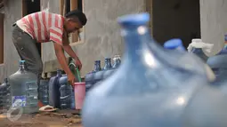 Seorang lelaki mengisi galon kosong yang berjejer untuk mendapatkan air bersih di Kawasan Manggarai, Jakarta, Selasa, (10/11). Hampir dua bulan warga RW 10 Manggarai Selatan harus antre untuk mendapat air bersih.(Liputan6.com/Gempur M Surya)