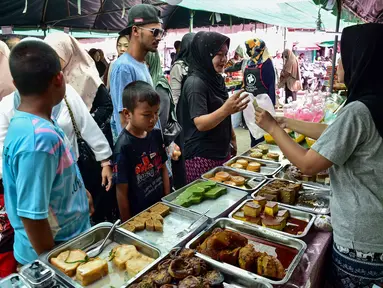 Orang-orang membeli makanan untuk berbuka puasa pada hari pertama bulan suci Ramadan 1447 Hijriah di sebuah pasar di provinsi Narathiwat, Thailand selatan, pada Kamis 19 Februari 2026. Jelang waktu berbuka puasa di hari pertama Ramadan 1447 Hijriah, suasana pasar-pasar lokal di provinsi Narathiwat, Thailand Selatan, terlihat semarak. (Madaree TOHLALA/AFP)