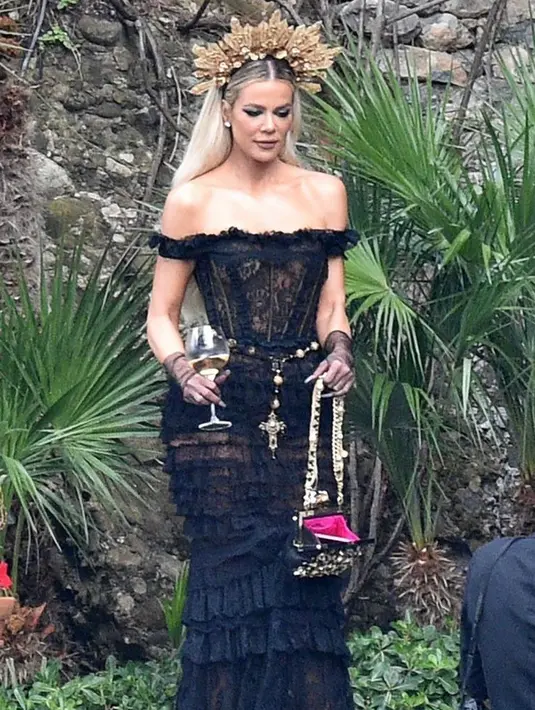 Tampil bak ratu, Khloe Kardashian, adik Kourtney mengenakan gaun renda hitam dengan hiasan mahkota emas untuk upacara pernikahan. (Instagram/enews).