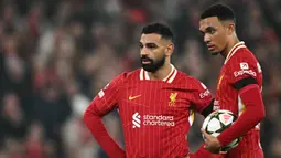 Pemain Liverpool, Mohamed Salah (kiri) berbincang dengan rekannya, Trent Alexander-Arnold saat laga lanjutan Liga Inggris 2024/2025 melawan Aston Villa yang berlangsung di Anfield, Liverpool, Inggris, Minggu (10/11/2024) WIB. (AFP/Paul Ellis)