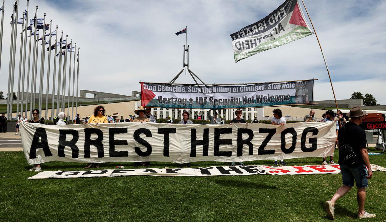 Kunjungan Presiden Israel, Isaac Herzog, akan berlangsung hingga 12 Februari 2026. Tampak dalam foto, para pengunjuk rasa berkumpul di depan gedung Parlemen menjelang pertemuan antara Perdana Menteri Australia Anthony Albanese dan Presiden Israel Isaac Herzog di Canberra pada Rabu 11 Februari 2026. (David GRAY/AFP)