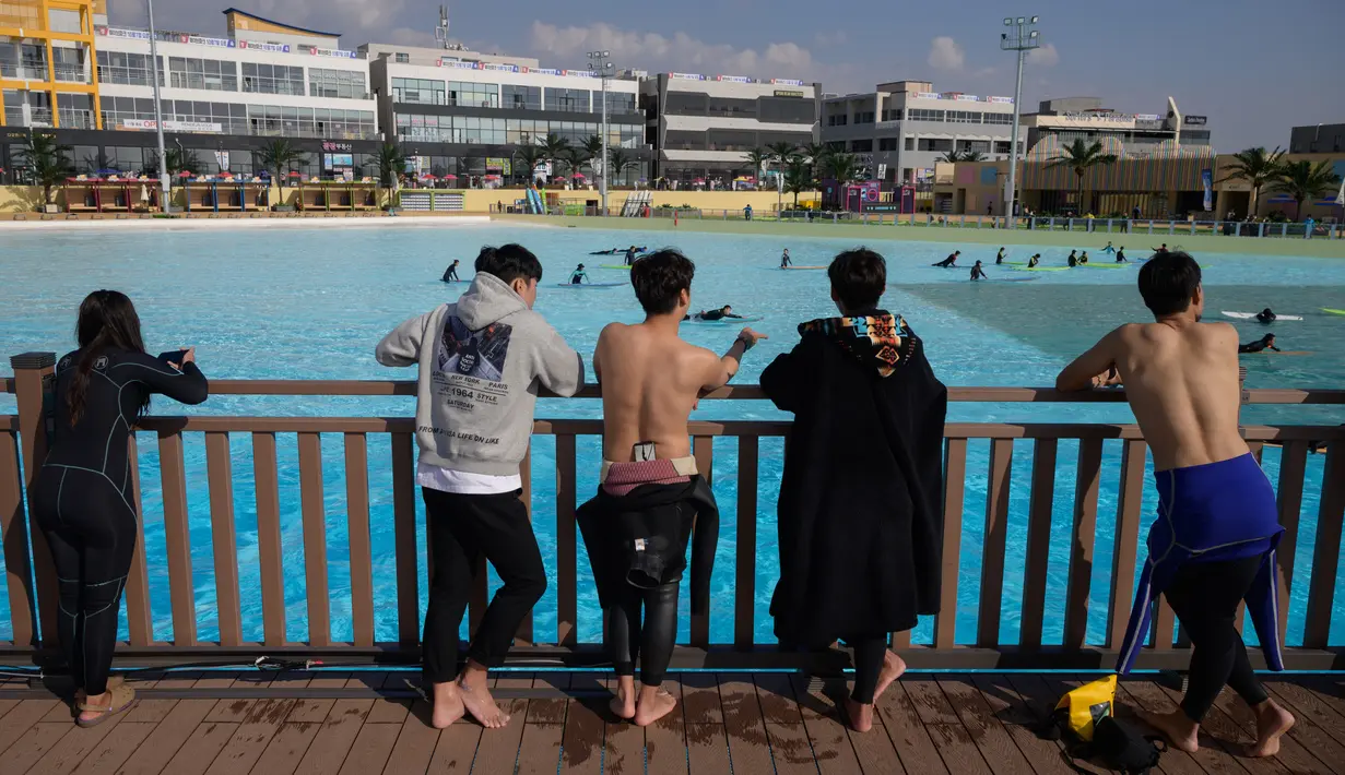 Pengunjung melihat peselancar di kolam ombak Wave Park di Siheung, Korea Selatan, 18 Oktober 2020. Kolam ombak terbesar di dunia ini merupakan bagian dari Siheung Surf Park, sebuah resor terletak di Pulau Penyu, yang akan mencakup sebuah hotel, pusat konvensi, marina, dan bianglala. (Ed JONES/AFP)