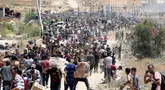 Orang-orang membawa kotak-kotak berisi pasokan bantuan dari Gaza Humanitarian Foundation (GHF), sebuah kelompok bantuan swasta yang didukung oleh Amerika Serikat (AS) yang telah melewati sistem yang telah lama dipimpin oleh PBB di wilayah tersebut, dari pusat distribusi bantuan di Jalur Gaza tengah pada 29 Mei 2025. (Eyad BABA/AFP)