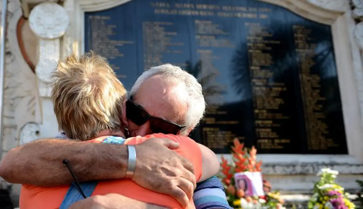 Dua warga asing berpelukan saat memperingati Tragedi Bom Bali I yang ke 14 di Monumen Ground Zero di Kuta, Bali, (12/10). Peristiwa ledakan bom di Jalan Legian ini merenggut 202 korban jiwa. (AFP Photo/ Sonny Tumbelaka)