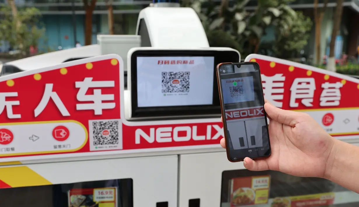 Pelanggan memindai kode QR pada kendaraan pengantar makanan otonomos untuk mendapatkan makanan di Taman Inovasi Huli, Xiamen, Provinsi Fujian, China, 6 November 2020. Para staf di tempat itu bisa mendapatkan makanan setelah membayar dengan memindai kode QR. (Xinhua/Zeng Demeng)