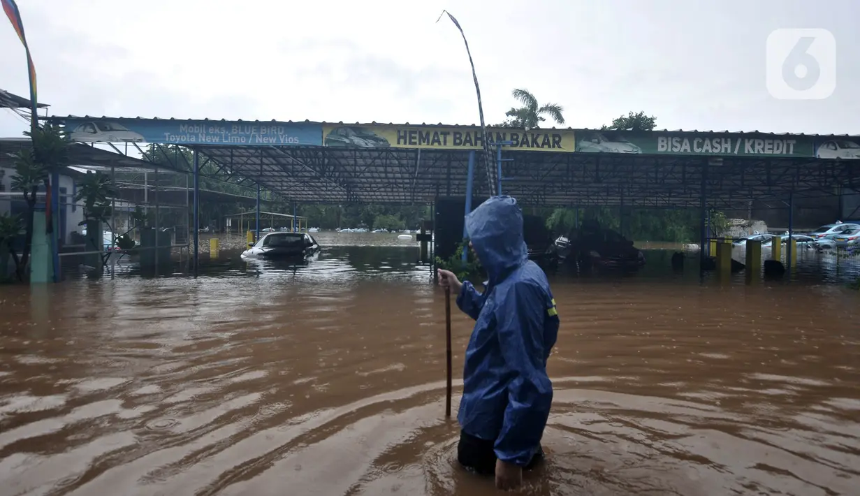 Seorang sopir melintasi banjir di Pool Blue Bird Kramat Jati, Jakarta, Rabu (1/1/2020). Akibat banjir setinggi hingga leher orang dewasa tersebut pool berhenti operasi dan sopir terpaksa diliburkan hingga waktu yang belum ditentukan. (merdeka.com/Iqbal S. Nugroho)