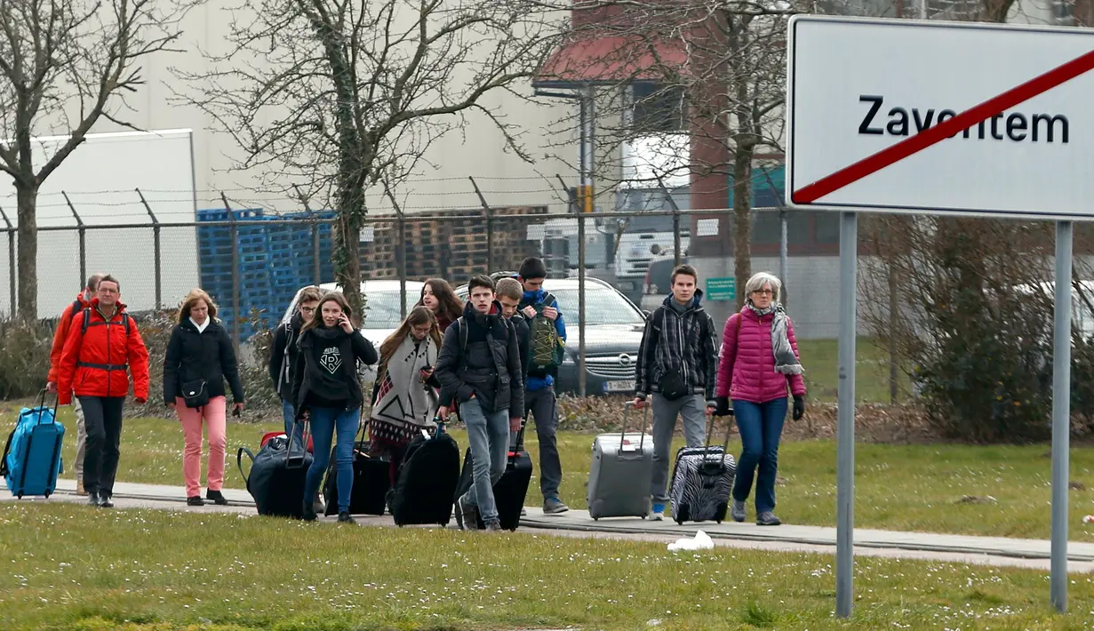 Sejumlah orang berjalan meninggalkan lokasi ledakan di bandara Zaventem dekat Brussels, Belgia, (22/3).Selain terjadi ledakan di Bandara, ledakan juga menghancurkan stasiun metro Maalbeek Brussels. (REUTERS / Francois Lenoir)