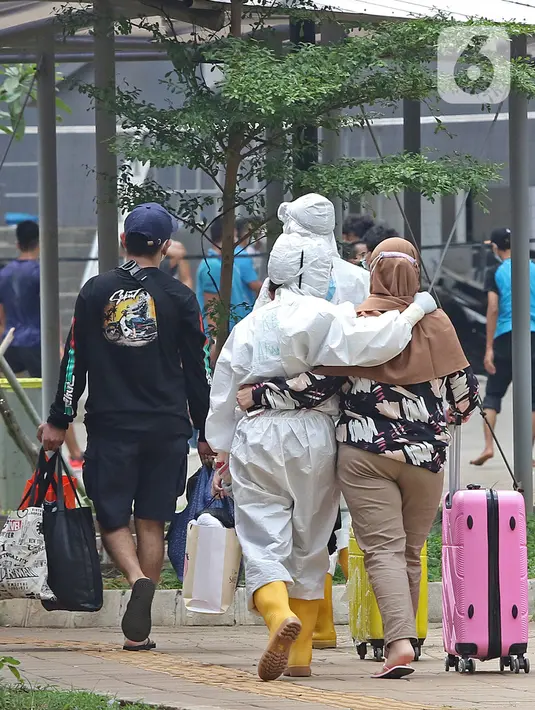 Tenaga kesehatan mendampingi pasien berstatus OTG (Orang Tanpa Gejala) yang tiba di RSDC Wisma Atlet, Jakarta, Selasa (26/1/2021). Hari ini, Selasa (26/1) kasus COVID-19 di Indonesia bertambah 13.094 sehingga total menyentuh angka satu juta, tepatnya 1.012.350. (Liputan6.com/Herman Zakharia)