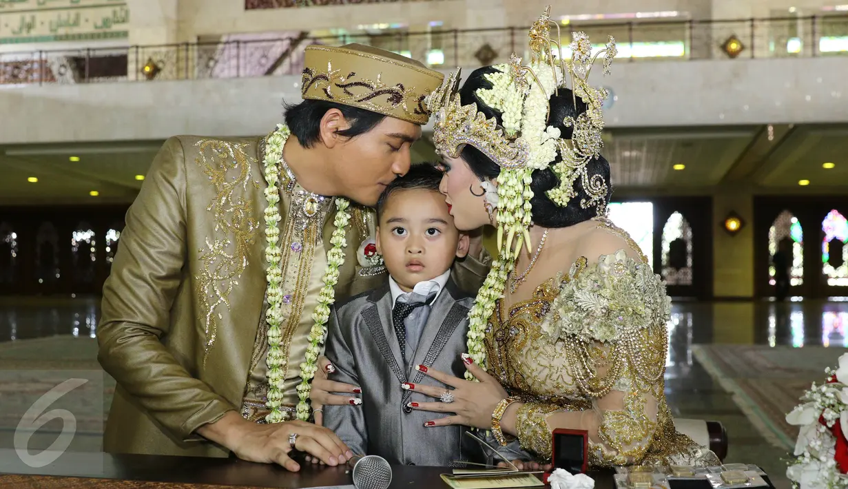 Lucky Hakim dan Tiara Dewi mencium anak Tiara Dewi seusai akad nikah di Masjid At Tin, Jakarta, Kamis (19/1/). Pernikahan Lucky dan Tiara berlangsung sederhana dan tak banyak kerabat dan tamu undangan yang hadir. (Liputan6.com/Herman Zakharia)