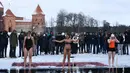 Tiga peserta wanita bersiap mengikuti kompetisi renang musim dingin tahunan dengan air es beku di Trakai, Lituania (24/2). Para peserta tetap antusias mengikuti lomba walaupun dengan suhu di luar hingga minus 12 derajat Celcius. (AFP Photo/Petras Malukas)