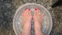 Rendam kaki di air es batu selama 15 menit! (Via: makeupandbeauty.com)