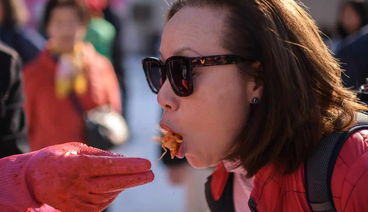 Seorang wanita mencoba kimchi selama festival pembuatan kimchi di Seoul (2/11). Festival pembuatan kimchi ini menandai awal musim dingin. (AFP Photo/Ed Jones)
