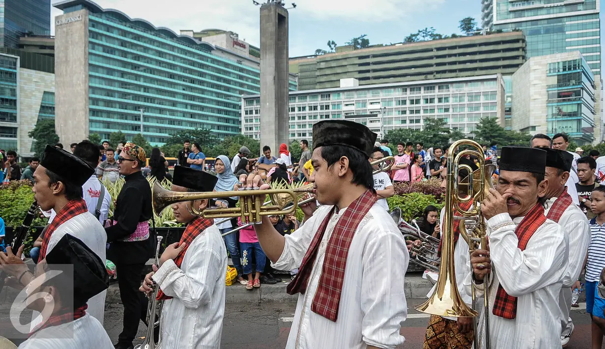 Grup Tanjidor ikut meramaikan acara Hajatan Bank DKI saat Car Free Day di kawasan Bundaran HI Jakarta, Minggu (16/10). Hajatan Bank DKI ini digelar dalam bentuk karnaval kebudayaan Betawi. (Liputan6.com/Faizal Fanani)