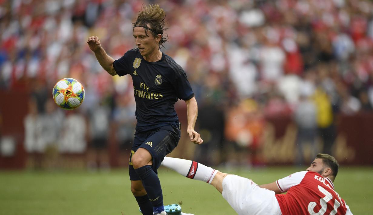 Gelandang Real Madrid, Luka Modric berusaha mengontrol bola dari kawalan bek Arsenal, Sead Kolasinac  selama pertandingan International Champions Cup (ICC) 2019 di FedExField, Landover, Maryland (24/7/2019). Madrid menang adu penalti atas Arsenal 3-2 (2-2). (AP Photo/Nick Wass)