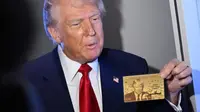 Donald Trump pamer prototipe yang memperlihatkan wajahnya dan tulisan “Trump Card”. (AFP)