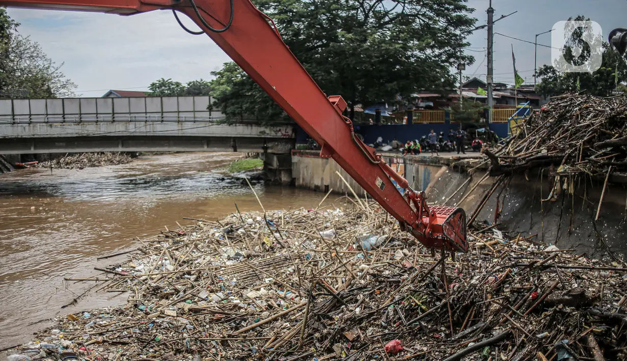 Pekerja kebersihan mengangkat sampah yang menumpuk di pintu air Manggarai, Jakarta, Selasa (22/9/2020). Tingginya curah hujan membuat kiriman sampah menumpuk di pintu air Manggarai. (Liputan6.com/Faizal Fanani)