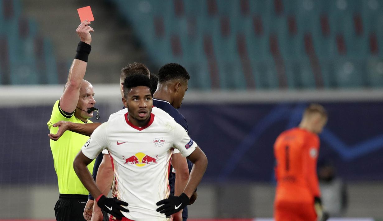 Wasit memberikan kartu merah kepada pemain Paris Saint Germain, Presnel Kimpembe, saat melawan RB Leipzig pada laga Liga Champions di RB Arena, Kamis (5/11/2020). RB Leipzig menang dengan skor 2-1. (AP/Michael Sohn)