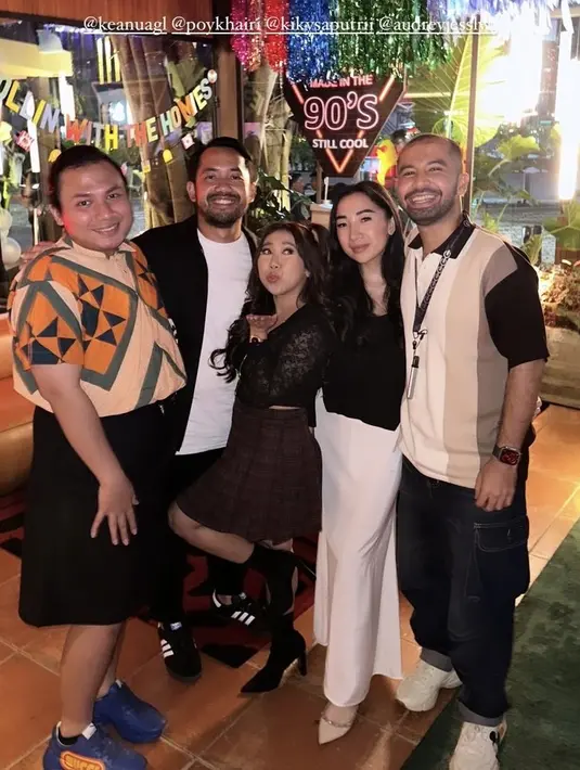 Kiky Saputri hadir mengenakan atasan crop top hitam lengan panjang dipadukan mini skirt kotak-kotak. Ia hadir bersama suami yang mengenakan jaket hitam. [@hassanalaydrus]