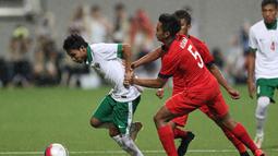 Pemain Indonesia U-23, Evan Dimas Darmono (kiri), berebut bola dengan pemain Singapura U-23. (Bola.com/Arief Bagus)