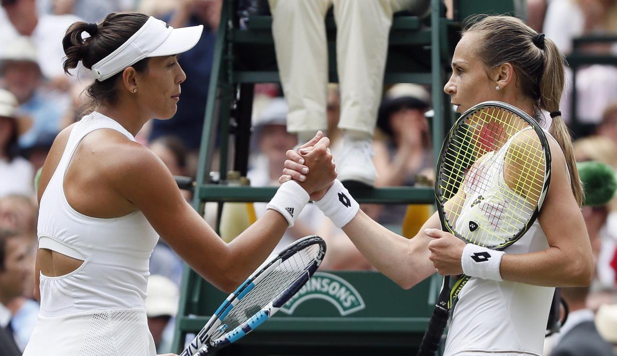 Garbine Muguruza (kiri) bersalaman dengan Magdalena Rybarikova usai laga semifinal tunggal putri Wimbledon 2017 di London; (13/7/2017). Muguruza menang 6-1, 6-1. (AP/Kirsty Wigglesworth)