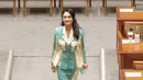 Busana etnik yang kontras juga pernah dikenakan Krisdayanti saat berkantor di DPR. Ia memilih memadukan kain bermotif warna biru muda dengan warna cream dalam potongan atasan blouse collar dan span skirt. Heels berwarna nude menjadi penutup cantik pada keseluruhan tampilan.